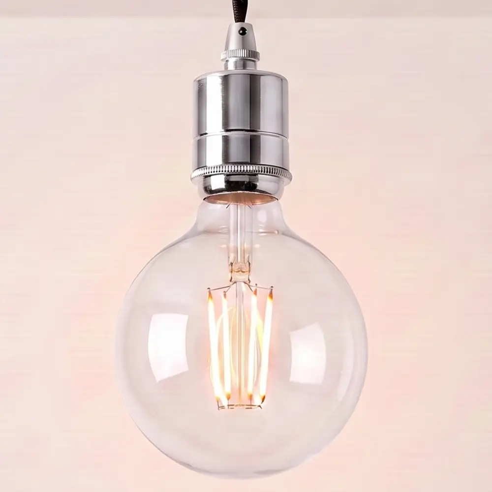 Close detail of the knurled chrome bulb holder and clear globe filament bulb