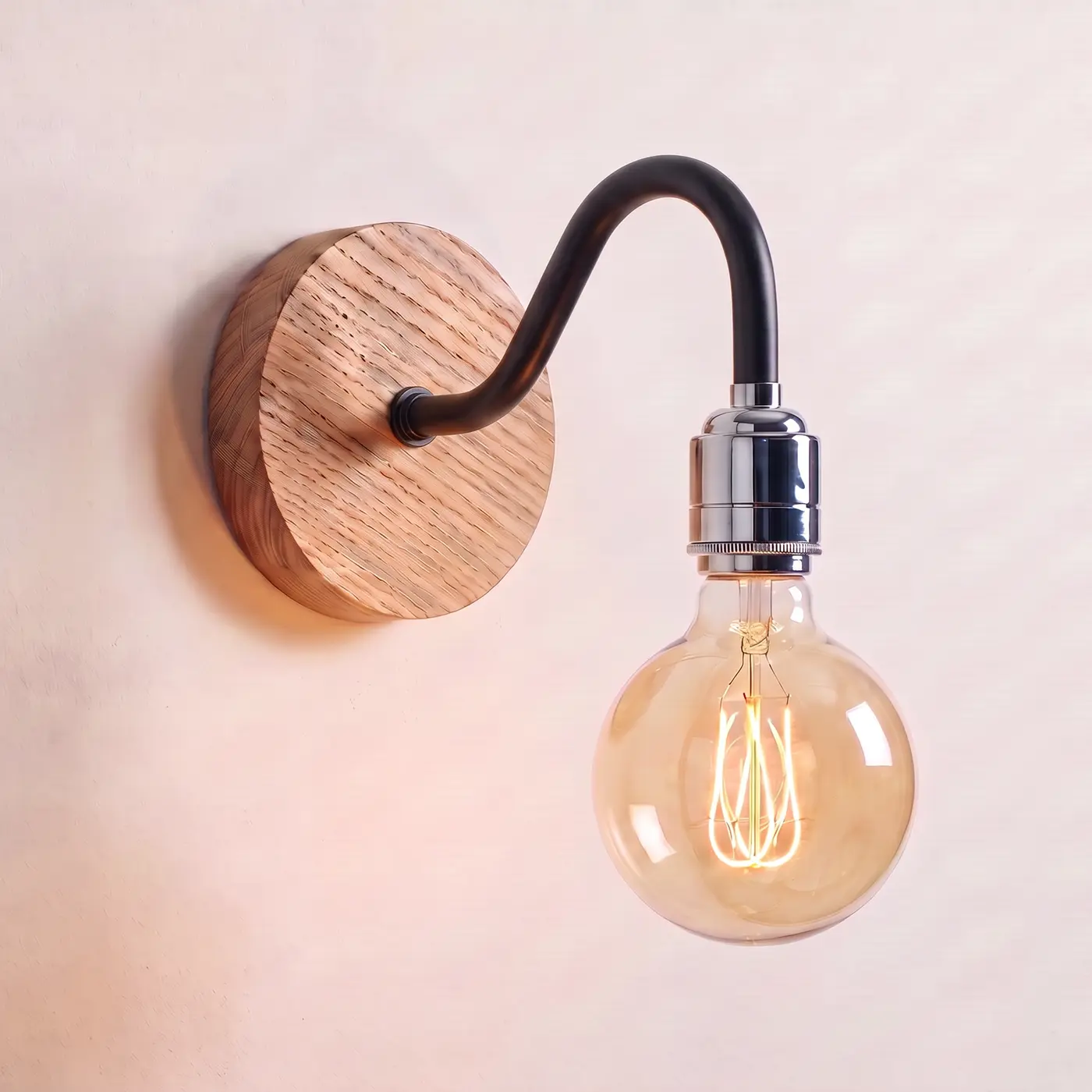 Swan neck wall light with a natural oak back plate, black swan neck arm and chrome bulb holder, lit with a globe filament bulb