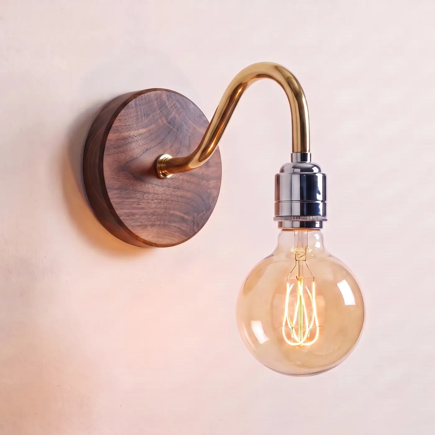 Swan neck wall light with a walnut back plate, brass swan neck arm and chrome bulb holder, lit with a globe filament bulb