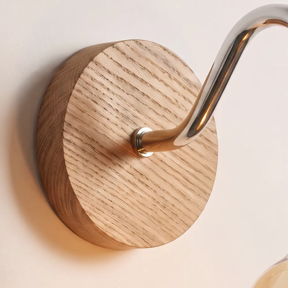 Close detail of the turned natural oak back plate and the chrome collar where the swan neck arm meets it