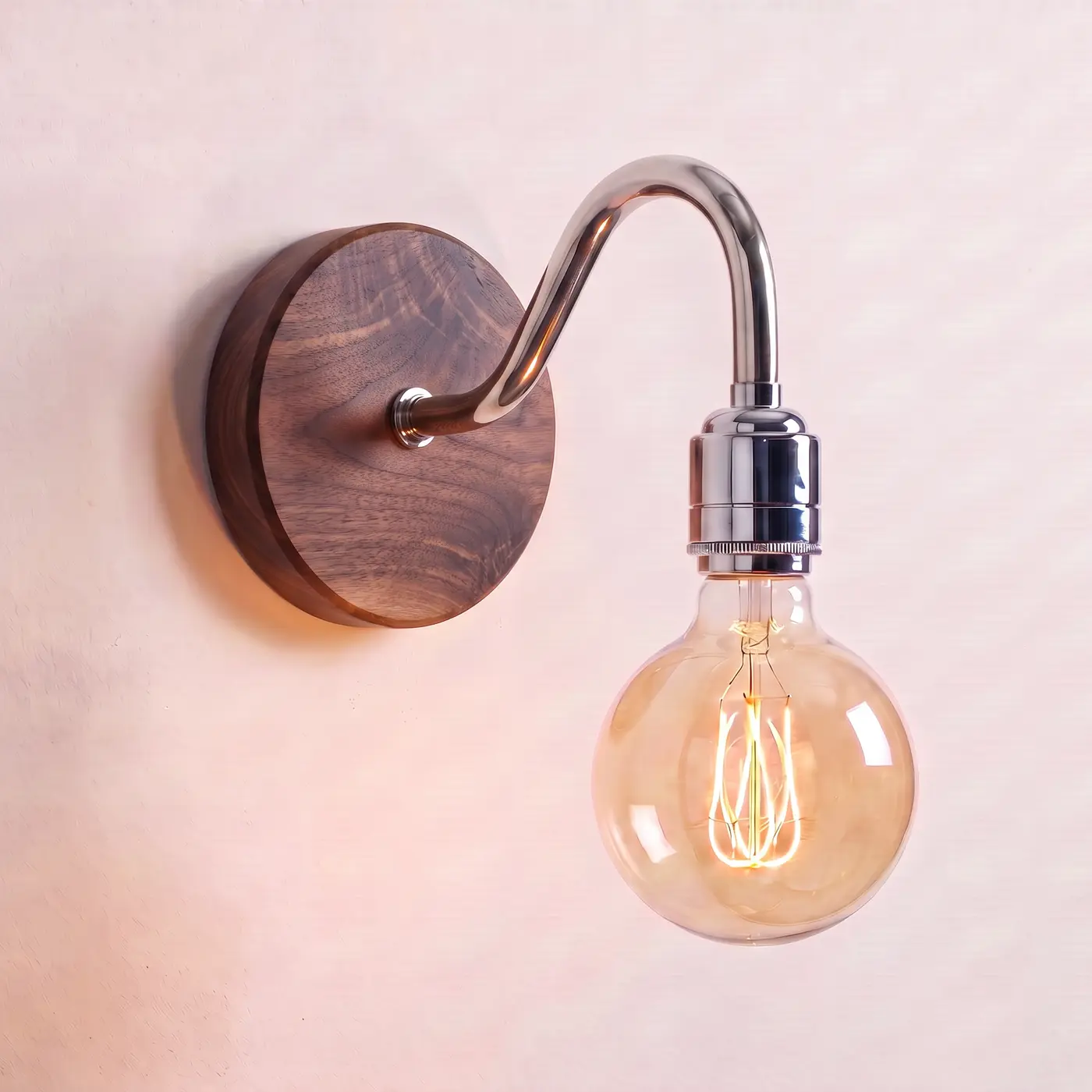 Swan neck wall light with a walnut back plate, chrome swan neck arm and matching bulb holder, lit with a globe filament bulb