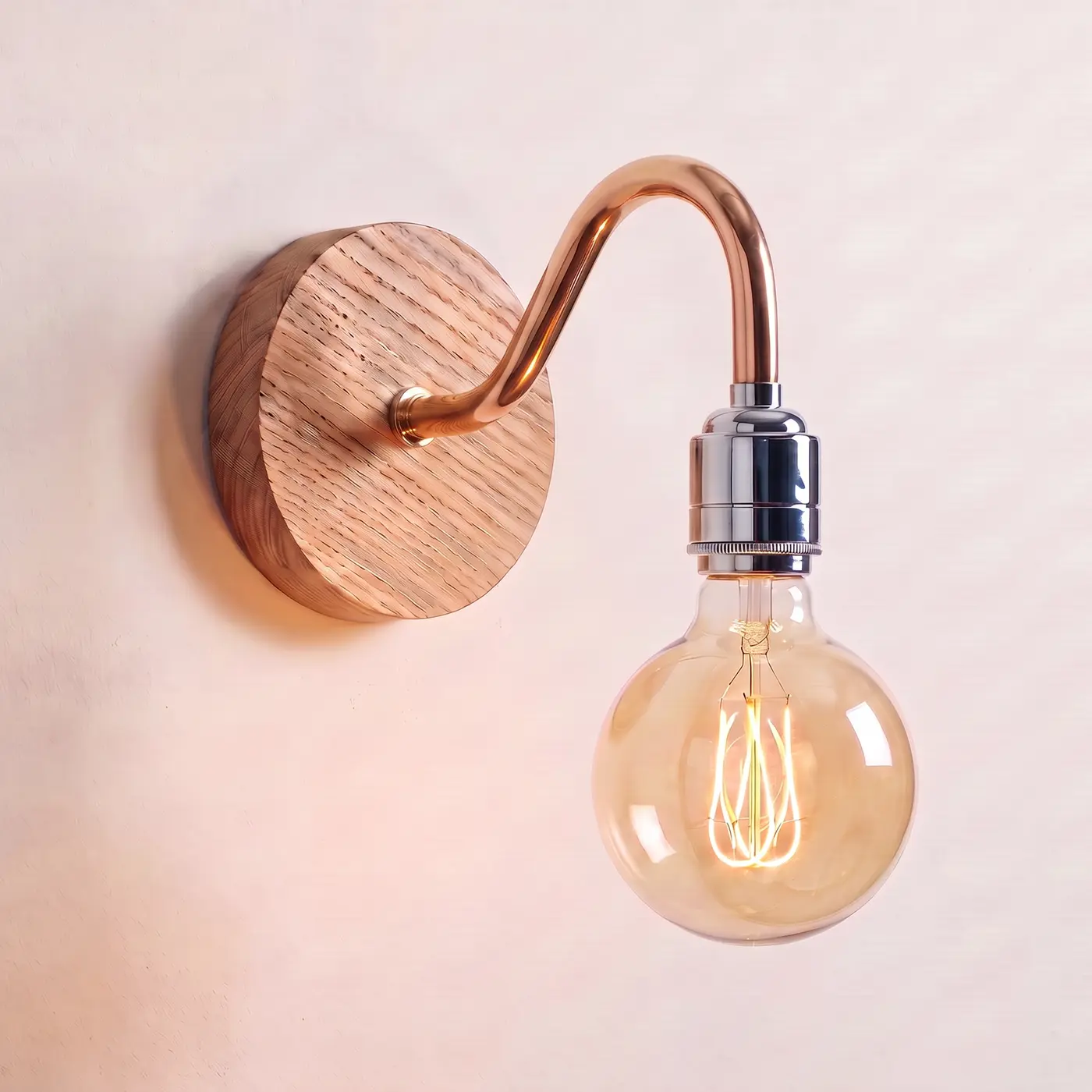 Swan neck wall light with a natural oak back plate, copper swan neck arm and chrome bulb holder, lit with a globe filament bulb