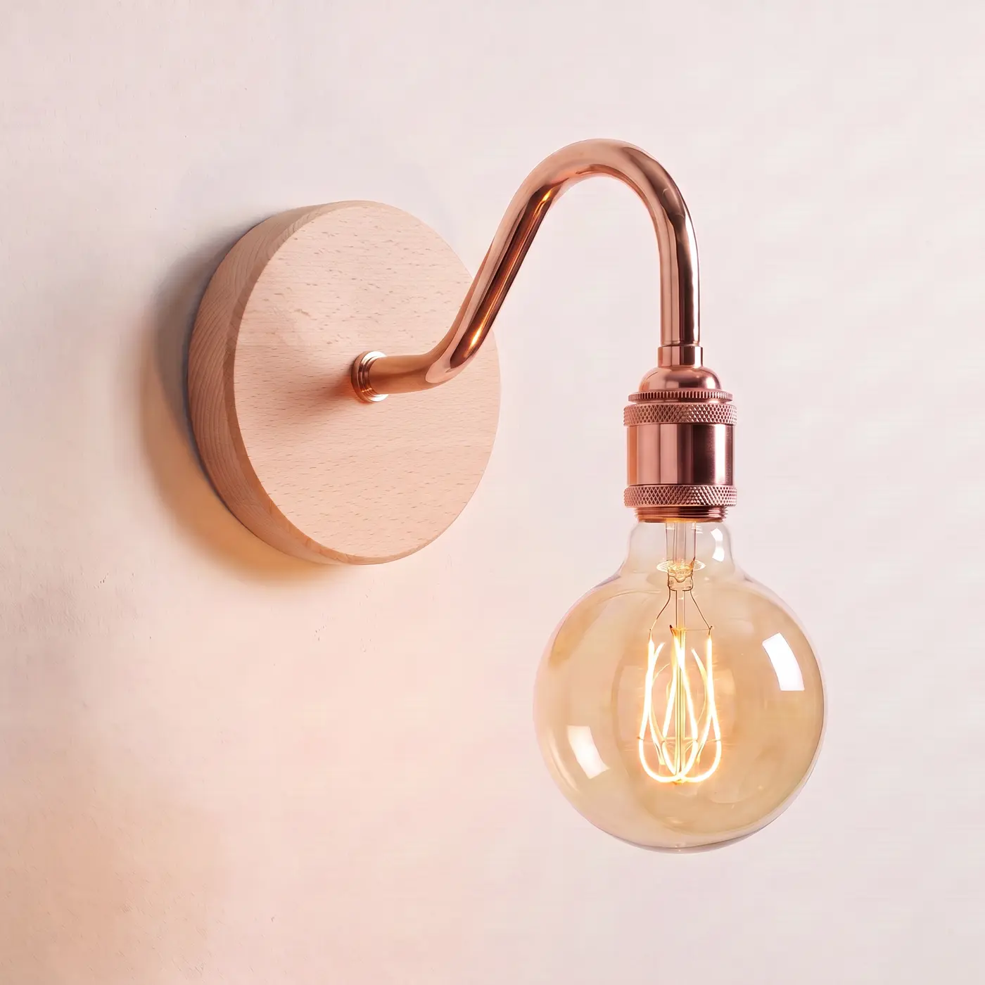 Swan neck wall light with a beech back plate, copper swan neck arm and matching bulb holder, lit with a globe filament bulb